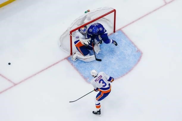 Brayden Point of the Tampa Bay Lightning is pushed from behind by Adam Pelech and into goalie Semyon Varlamov of the New York Islanders during the...