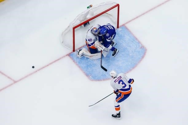 Brayden Point of the Tampa Bay Lightning is pushed from behind by Adam Pelech and into goalie Semyon Varlamov of the New York Islanders during the...