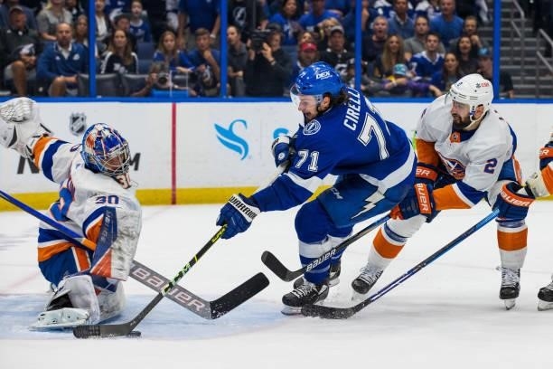 Anthony Cirelli of the Tampa Bay Lightning skates against Nick Leddy and goalie Ilya Sorokin of the New York Islanders during the first period in...
