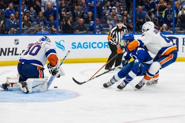 Yanni Gourde of the Tampa Bay Lightning skates against goalie Semyon Varlamov and Noah Dobson of the New York Islanders during the third period in...