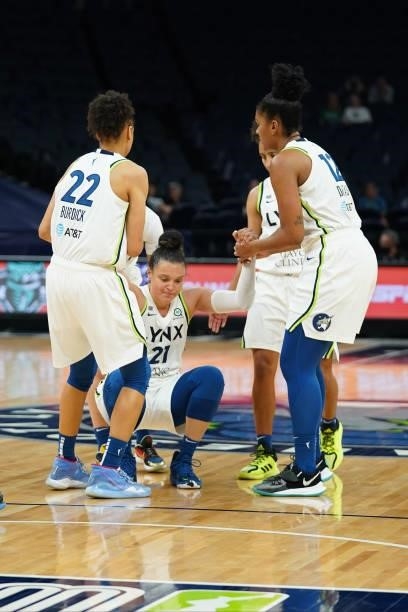 Kayla McBride of the Minnesota Lynx gets helped up by teammates during the game against the Chicago Sky on June 15, 2021 at Target Center in...