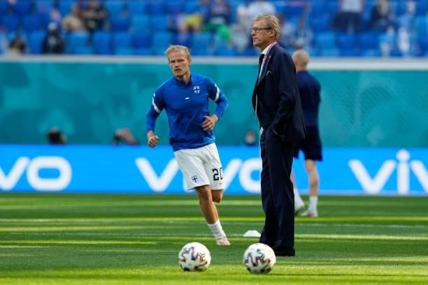 Finland's coach Markku Kanerva stand on the pitch as Finland's forward Joel Pohjanpalo warms up prior to during the UEFA EURO 2020 Group B football...
