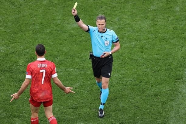 Dutch referee Danny Makkelie shows a yellow card to Russia's midfielder Magomed Ozdoev during the UEFA EURO 2020 Group B football match between...