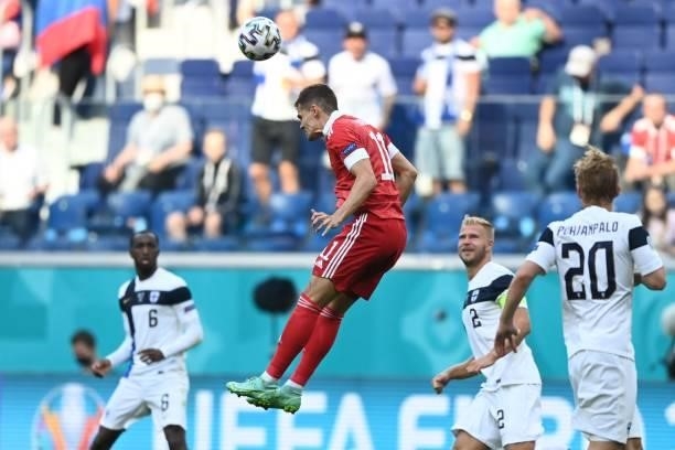 Russia's midfielder Roman Zobnin jumps to head the ball during the UEFA EURO 2020 Group B football match between Finland and Russia at the Saint...