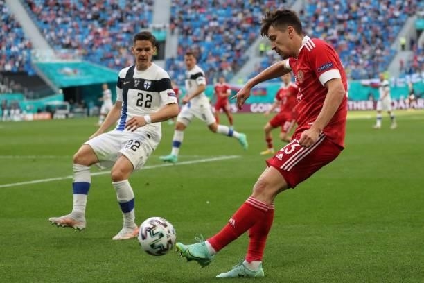 Russia's midfielder Daler Kuzyaev shoots past Finland's defender Jukka Raitala during the UEFA EURO 2020 Group B football match between Finland and...