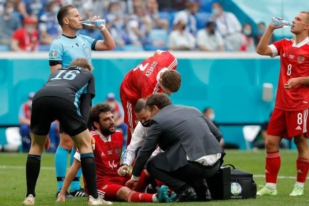 Russia's defender Georgiy Dzhikiya receives medical attention during the UEFA EURO 2020 Group B football match between Finland and Russia at the...