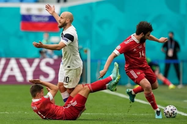 Russia's midfielder Roman Zobnin and Finland's forward Teemu Pukki react as Russia's defender Georgiy Dzhikiya controls the ball during the UEFA EURO...