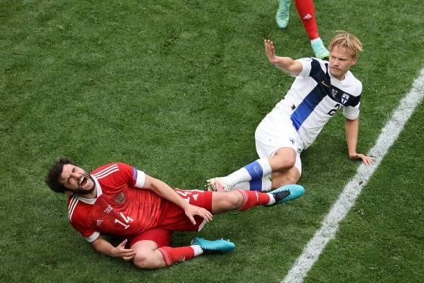 Russia's defender Georgiy Dzhikiya reacts after a challange by Finland's forward Joel Pohjanpalo during the UEFA EURO 2020 Group B football match...