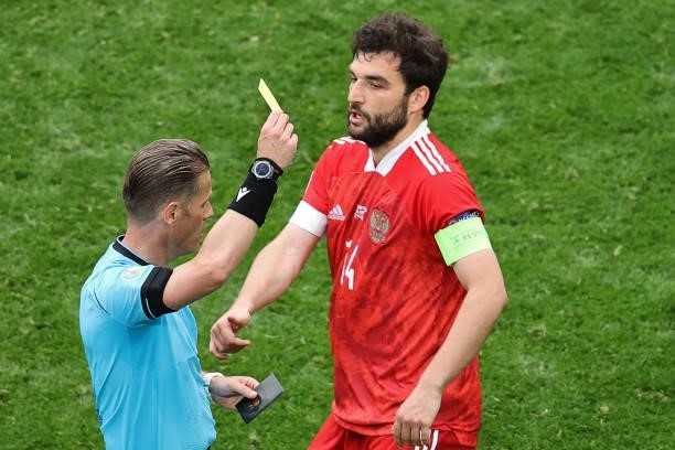 Russia's defender Georgi Dzhikiya is is shown a yellow card by Dutch referee Danny Makkelie during the UEFA EURO 2020 Group B football match between...