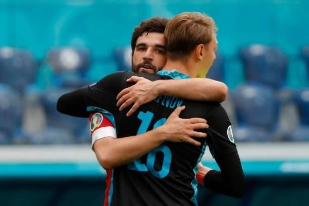 Russia's goalkeeper Matvei Safonov and Russia's defender Georgiy Dzhikiya celebrate after the final whistle of the UEFA EURO 2020 Group B football...
