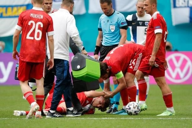 Russia's midfielder Dmitriy Barinov receives medical attention during the UEFA EURO 2020 Group B football match between Finland and Russia at the...