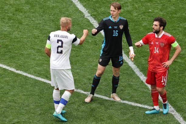 Russia's goalkeeper Matvei Safonov and Russia's defender Georgiy Dzhikiya are congratulated by Finland's defender Paulus Arajuuri after the final...