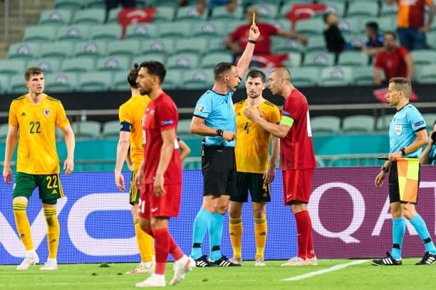 Referee Artur Dias of Portugal shows a yellow card for Burak Yilmaz of Turkey during the UEFA Euro 2020 Championship Group A match between Turkey and...