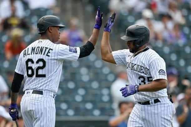 Elias Diaz of the Colorado Rockies celebrates with Yency Almonte after hitting a fourth inning solo home run against the San Diego Padres at Coors...