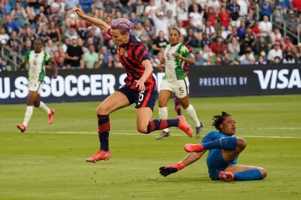 Megan Rapinoe of the United States leaps over goalkeeper Tochukwu Oluehi of Nigeria during the first half of their WNT Summer Series game at Q2...