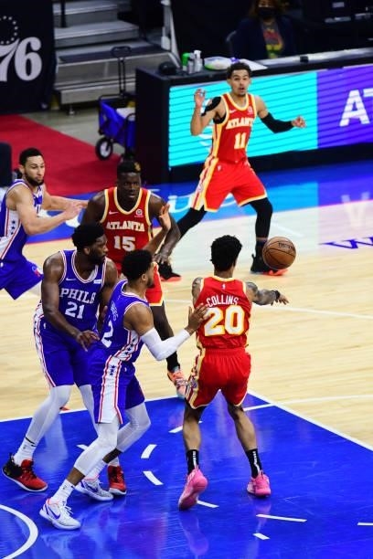John Collins of the Atlanta Hawks passes the ball to Trae Young of the Atlanta Hawks against the Philadelphia 76ers in game 5 of the conference...