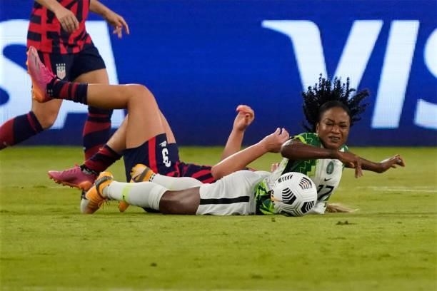 Francisca Ordega of Nigeria and Lindsey Horan of the United States fall while competing for the ball during the first half of their WNT Summer Series...