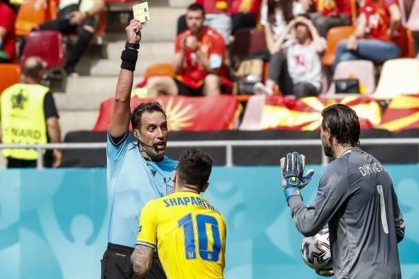Argentinian referee Fernando Rapallini gives a yellow card to Ukraine's midfielder Mykola Shaparenko for a simulation foul during the UEFA EURO 2020...
