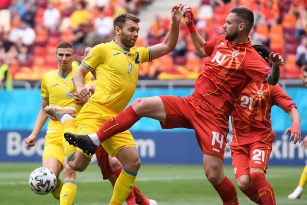 Oleksandr Karavaev of Ukraine and Darko Velkovski of North Macedonia battle for the ball during the UEFA Euro 2020 Championship Group C match between...