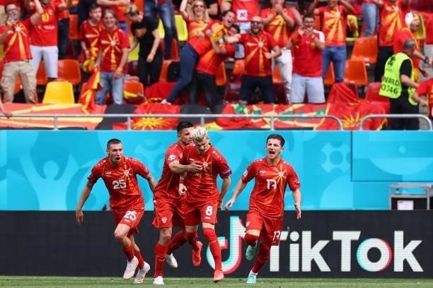 North Macedonia's defender Ezgjan Alioski celebrates with teammates after scoring his team's first goal during the UEFA EURO 2020 Group C football...