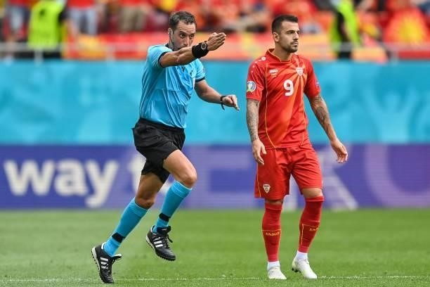 Argentinian referee Fernando Rapallini gestures next to North Macedonia's forward Aleksandar Trajkovski during the UEFA EURO 2020 Group C football...