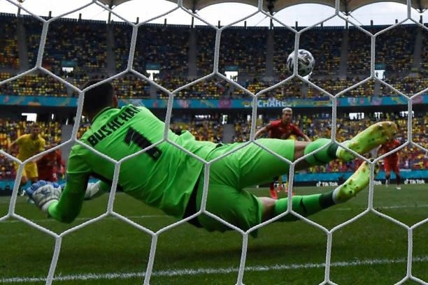 Ukraine's goalkeeper Georgiy Bushchan deflects and saves a penalty during the UEFA EURO 2020 Group C football match between Ukraine and North...