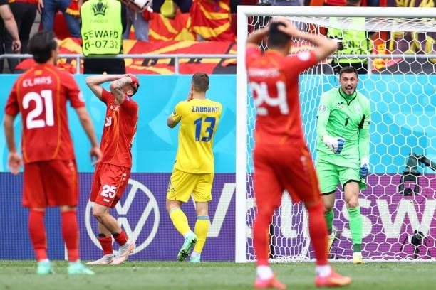 Ukraine's goalkeeper Georgiy Bushchan and Ukraine's defender Illia Zabarnyi celebrate winning as North Macedonia's players reacts at the end of the...