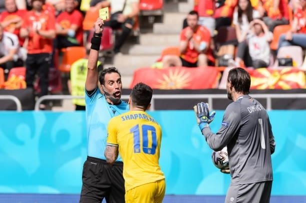 Referee Fernando Andres Rapallini, Mykola Shaparenko of Ukraine and Stole Dimitrievski of North Macedonia shows the yellow card during the UEFA Euro...
