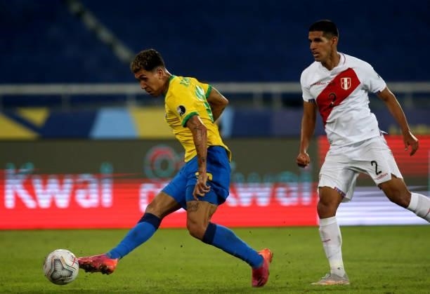 Roberto Firmino of Brazil competes for the ball with Luis Abram of Peru during the match between Brazil and Peru as part of Conmebol Copa America...