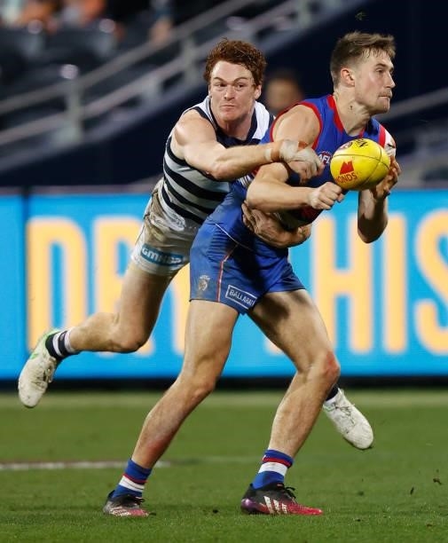 Ryan Gardner of the Bulldogs is tackled by Gary Rohan of the Cats during the 2021 AFL Round 14 match between the Geelong Cats and the Western...