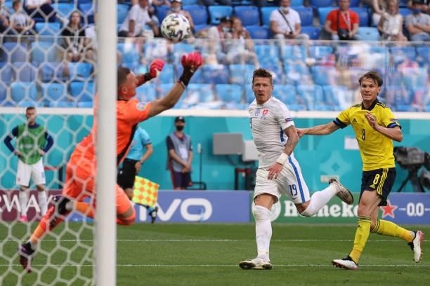 Sweden's midfielder Albin Ekdal challenges Slovakia's midfielder Juraj Kucka as Sweden's goalkeeper Robin Olsen stops a shot on goal during the UEFA...