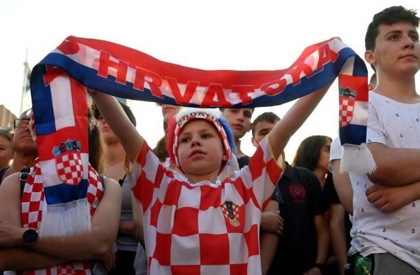Young supporter holds a scarf as people watch a broadcast of the UEFA EURO 2020 football match between Croatia and Czech Republic at the Jelacic...