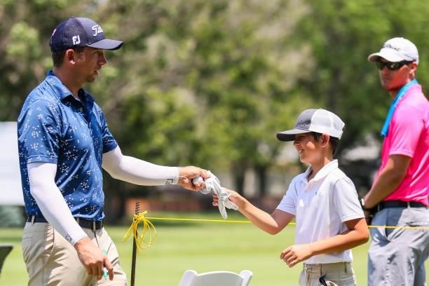 Chandler Blanchet gives a young fan an autographed glove after sinking his putt on the 18th green during the second round of the Wichita Open...