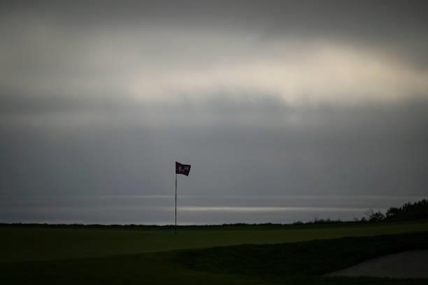 Scenic view of a pin flag on the 14th hole as a marine layer of clouds and fog obscures the sun over the Pacific Ocean during the first round of the...