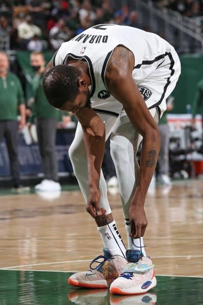Kevin Durant of the Brooklyn Nets ties his sneakers against the Milwaukee Bucks during Round 2, Game 5 of the 2021 NBA Playoffs on June 17, 2021 at...