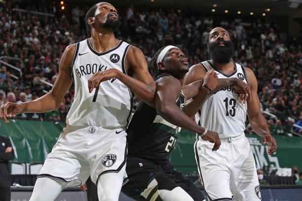 Kevin Durant, James Harden of the Brooklyn Nets and Jrue Holiday of the Milwaukee Bucks look up during Round 2, Game 6 of the 2021 NBA Playoffs on...