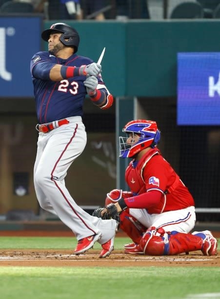 Nelson Cruz of the Minnesota Twins breaks his bat with a run scoring single as Jose Trevino of the Texas Rangers looks on during the first inning at...