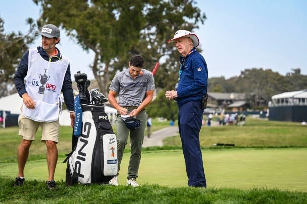 Viktor Hovland signs his scorecard in front of USGA Rules Official Phil Miller after withdrawing from the tournament on the first hole during the...
