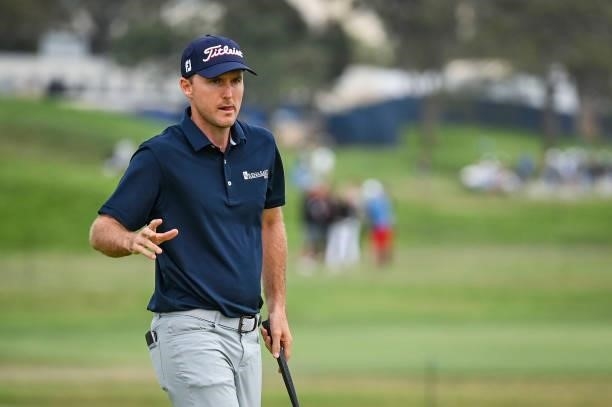 Russell Henley waves to fans after making a par putt on the sixth hole green during the second round of the 121st U.S. Open on the South Course at...