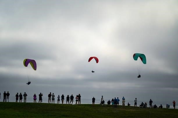 Fans watch play on the fourth hole as paragliders fly by during the second round of the 121st U.S. Open on the South Course at Torrey Pines Golf...
