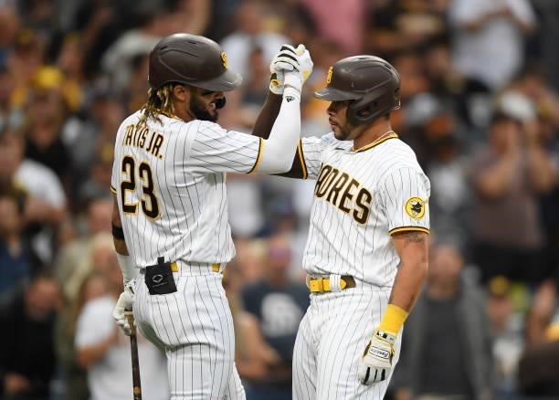 Tommy Pham of the San Diego Padres is congratulated by Fernando Tatis Jr. #23 after hitting a solo home run during the first inning of a baseball...