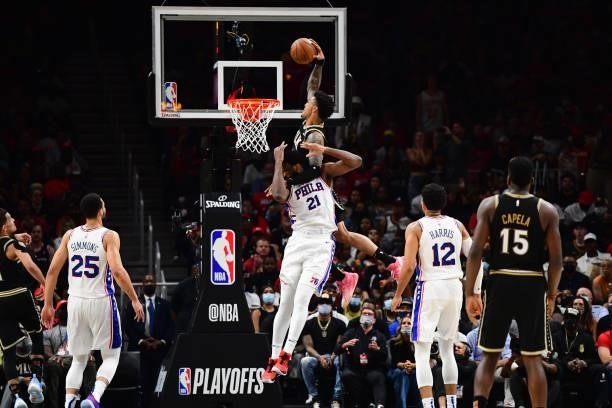 John Collins of the Atlanta Hawks dunks the ball against Joel Embiid of the Philadelphia 76ers during Round 2, Game 6 of the Eastern Conference...
