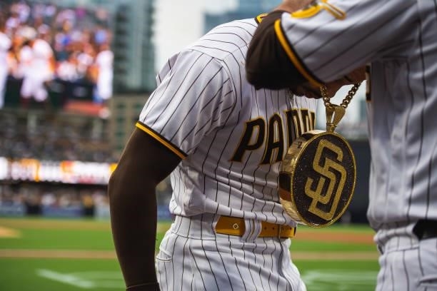 Tommy Pham of the San Diego Padres has the 'swag chain' placed on him after hitting a home run in the first inning against the Cincinnati Reds on...