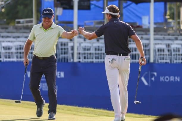 James Nicholas and Andre Metzger fist bump after Metzger sunk his putt on the 17th green during the second round of the Wichita Open Benefitting KU...