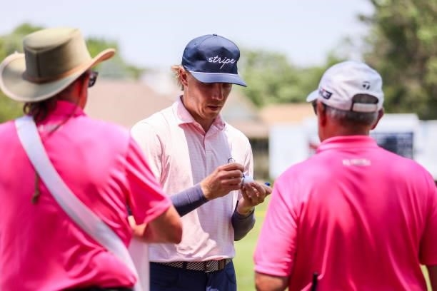 Max Rottluff autographs golf balls as a thank you to volunteers after sinking his putt on the 18th green during the second round of the Wichita Open...