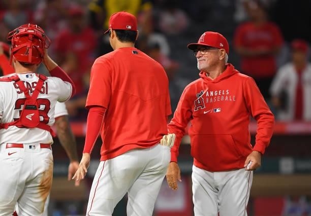 Shohei Ohtani of the Los Angeles Angels gets a high five from manager Joe Maddon after the game against the Detroit Tigers at Angel Stadium of...