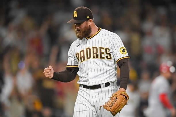 Austin Adams of the San Diego Padres pumps his fist after getting the final out during the ninth inning of a baseball game against the Cincinnati...