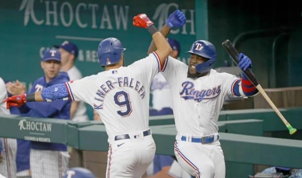 Isiah Kiner-Falefa of the Texas Rangers celebrates with teammate Adolis Garcia after hitting a two-run home run against the Minnesota Twins during...