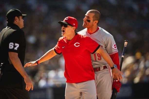 Joey Votto is held back by manager David Bell of the Cincinnati Reds after being ejected against the San Diego Padres on June 19, 2021 at Petco Park...