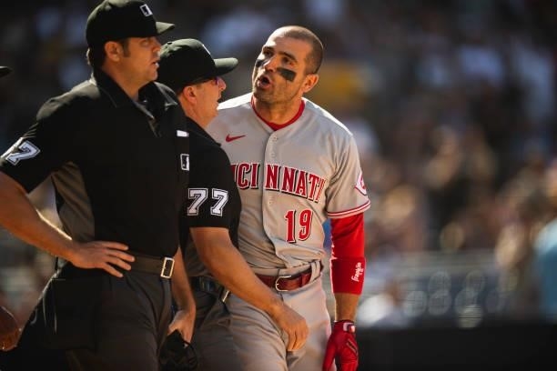 Joey Votto of the Cincinnati Reds is held back while arguing with the home plate umpire after being ejected against the San Diego Padres on June 19,...
